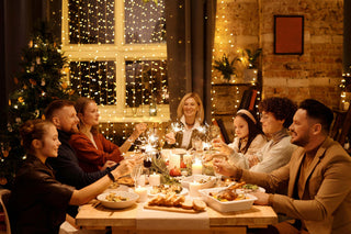 Group of people enjoying a festive meal together with Christmas decorations.