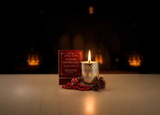 Decorative candle with packaging on a reflective surface with a dark background